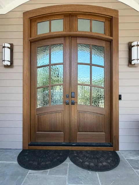 Arched solid wood entry doors and custom molding by Ocean Bay Interiors
