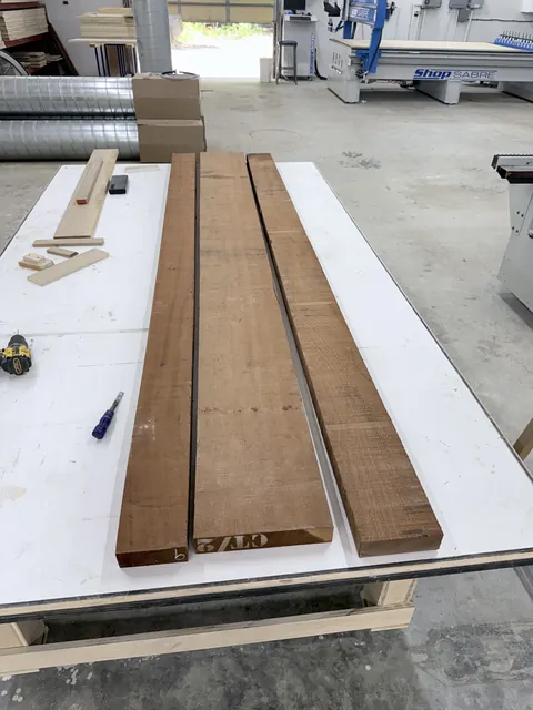 Carved clubhouse sign, rough mahogany boards in the shop (Commercial)