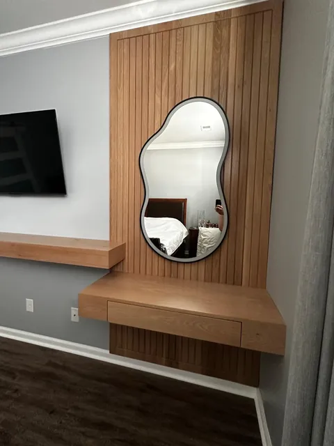 Custom oak slat wall with floating vanity shelf and backlit mirror