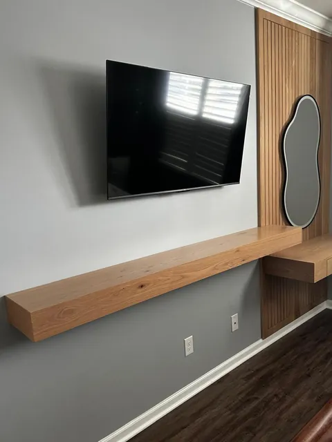Custom oak slat wall with floating vanity shelf and backlit mirror