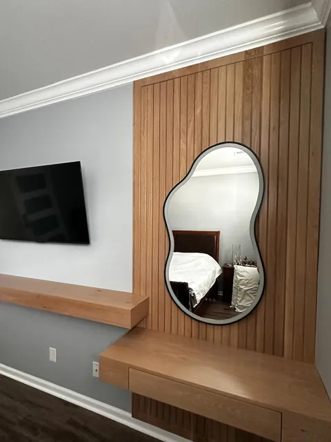 Custom oak slat wall with floating vanity shelf and backlit mirror