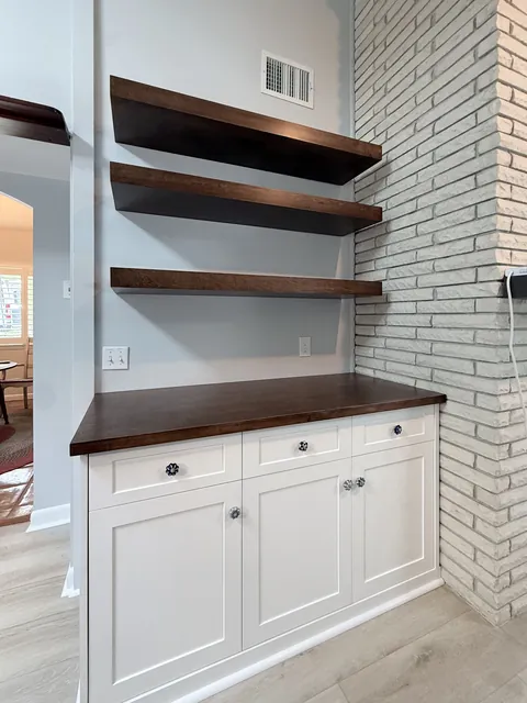 Walnut floating shelves and white shaker base cabinets