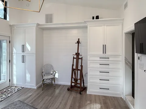 White custom closet and entry cabinetry with a navy vanity