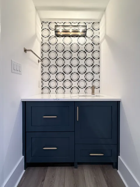 White custom closet and entry cabinetry with a navy vanity