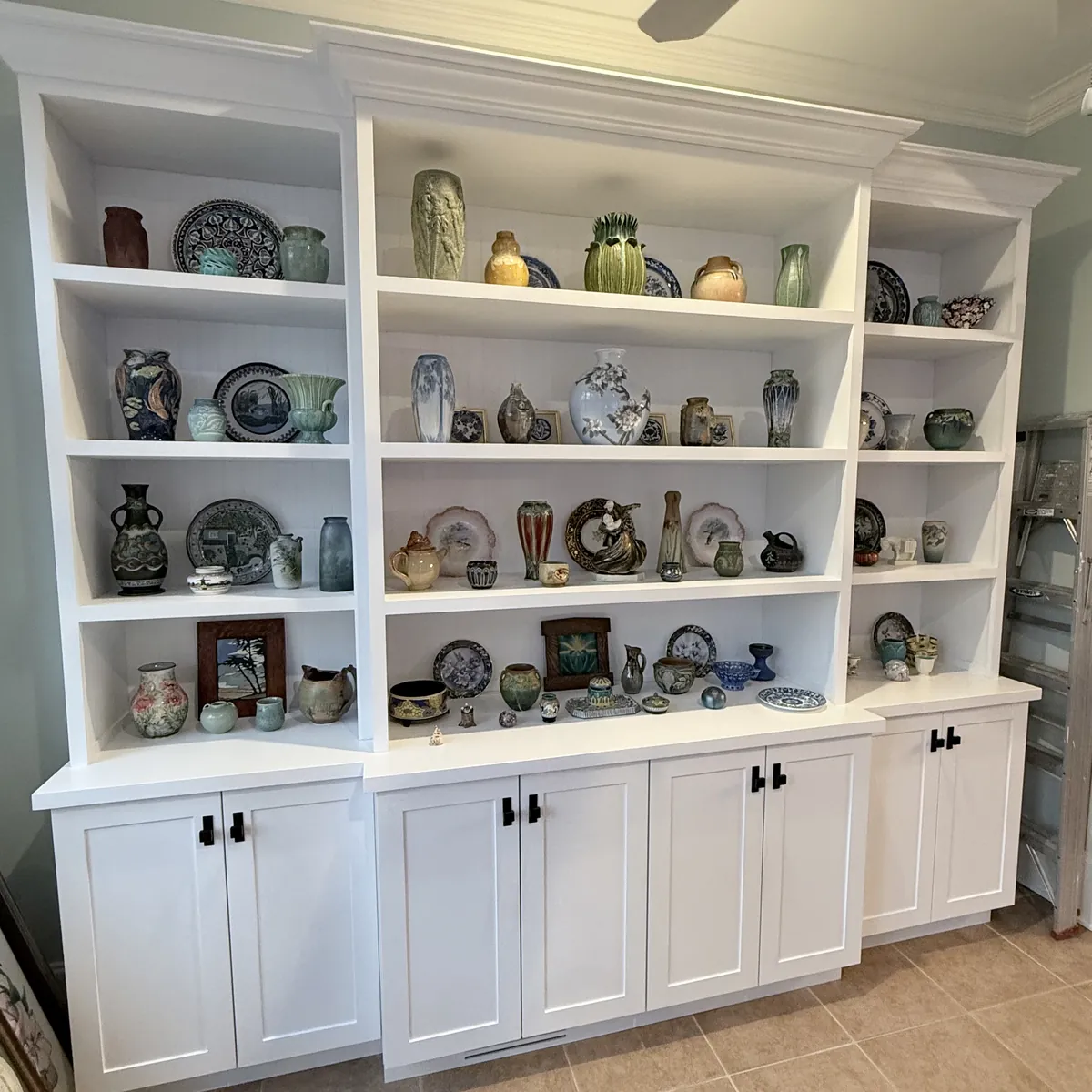 The finished white display wall installed in Larry's home, matching the 3D design